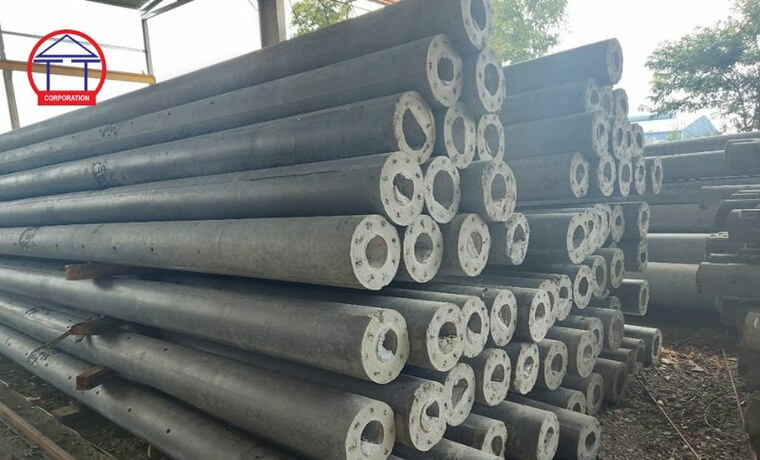 Cột điện bê tông ly tâm: phân nhóm, ký hiệu và cách chọn Các cột điện bê tông ly tâm xếp tại bãi thành phẩm, nhìn rõ mặt cắt tròn có lòng rỗng ở giữa và chiều dày thành bê tông